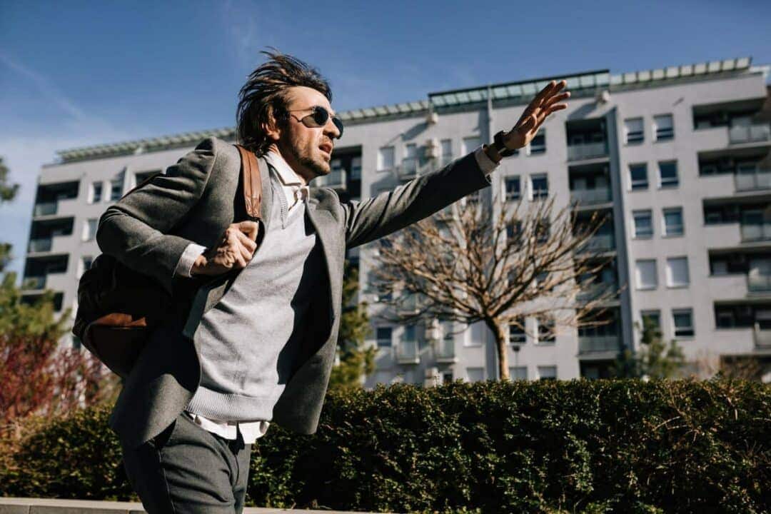 Homem correndo com mochila nas costas, aparentemente atrasado para o trabalho