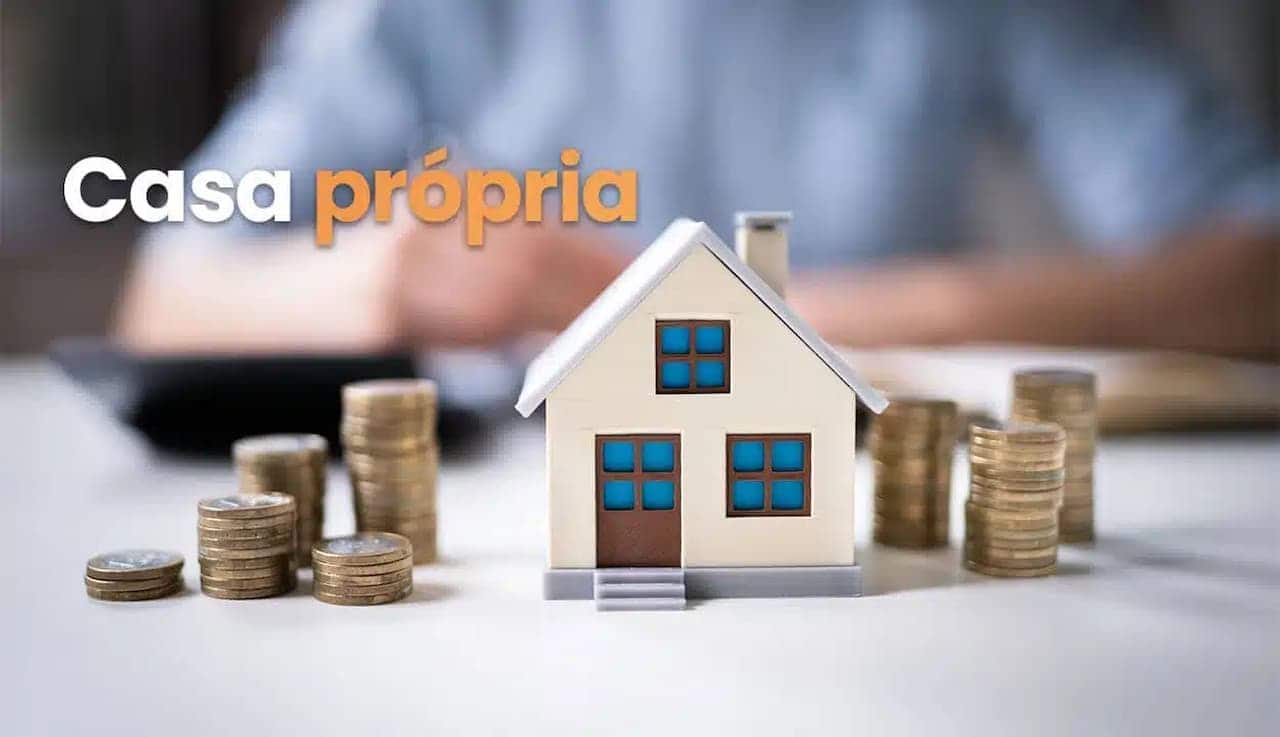 Representação de uma casa em miniatura e várias moedas empilhadas, ao lado esquerdo está escrito casa própria, ao fundo tem uma pessoa desfocada.