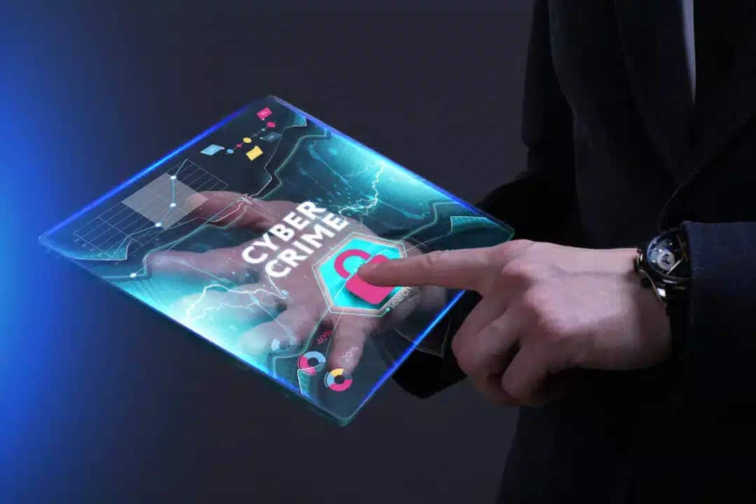 Tela digital com um cadeado sendo tocado pelo indicador de uma pessoa representando crimes virtuais.