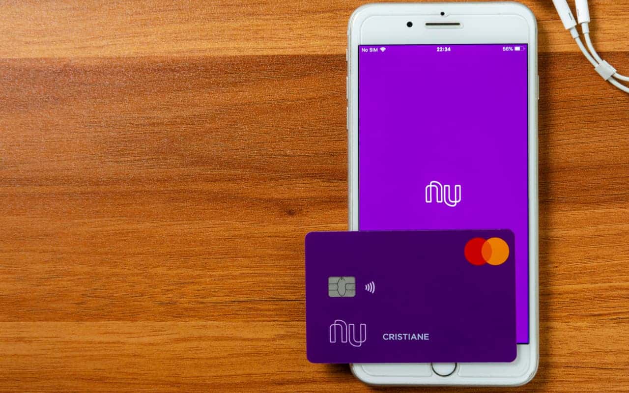 Celular com logo do Nubank na tela e cartão roxinho em cima