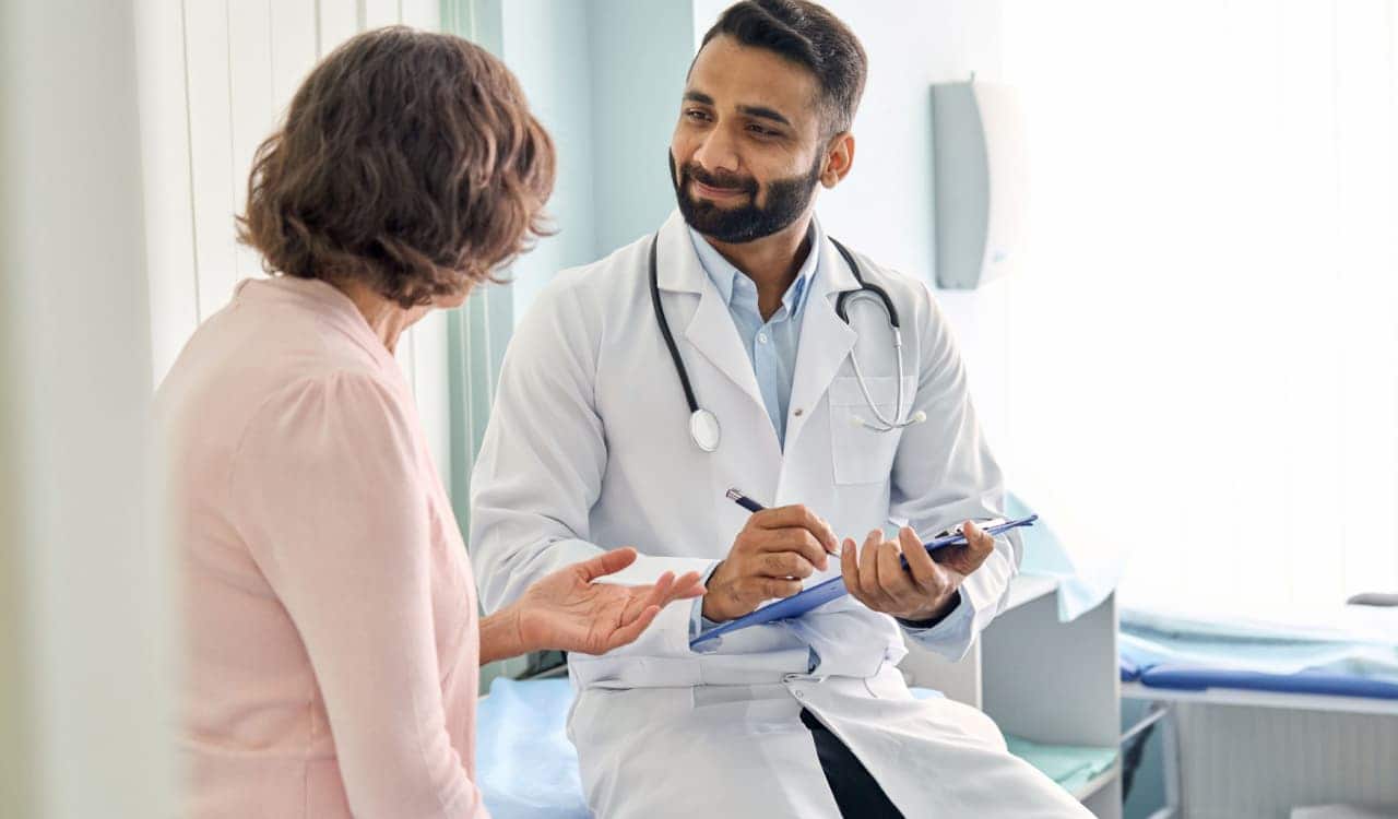 Médico sorrindo enquanto olha para paciente