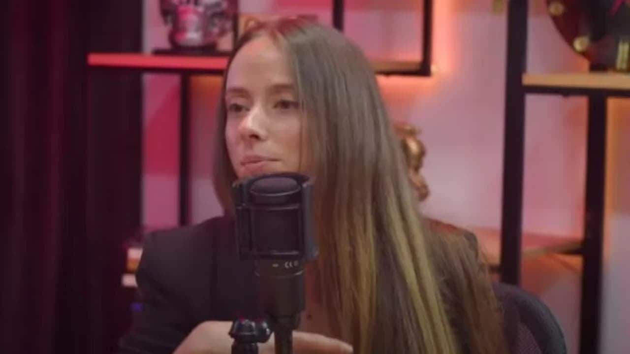 Mulher em frente à um microfone de podcast