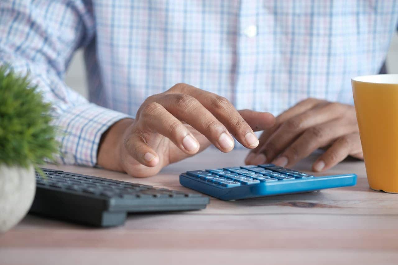 Imagem de uma pessoa mexendo em uma calculadora