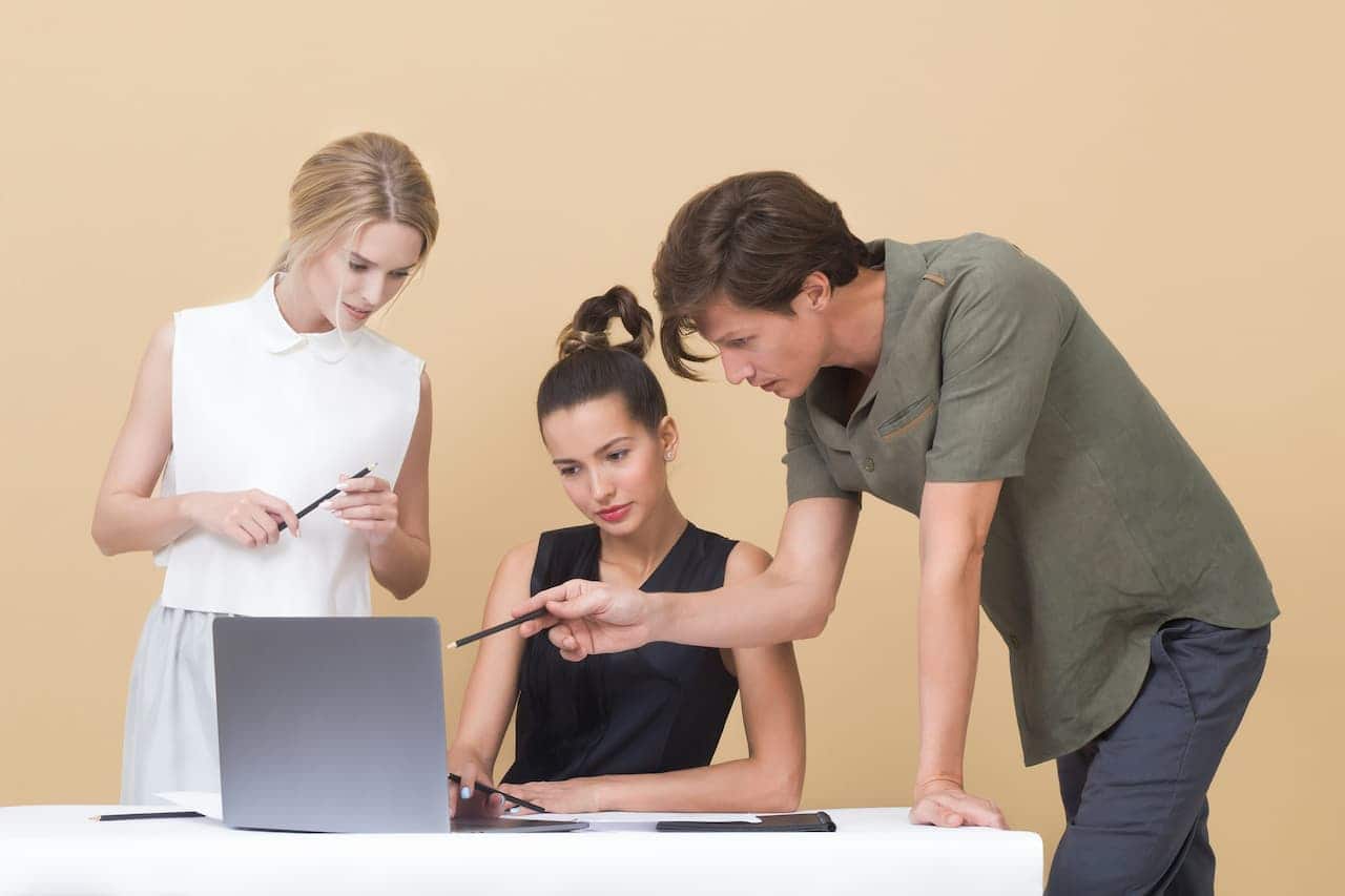 Três jovens olhando para a tela de um notebook
