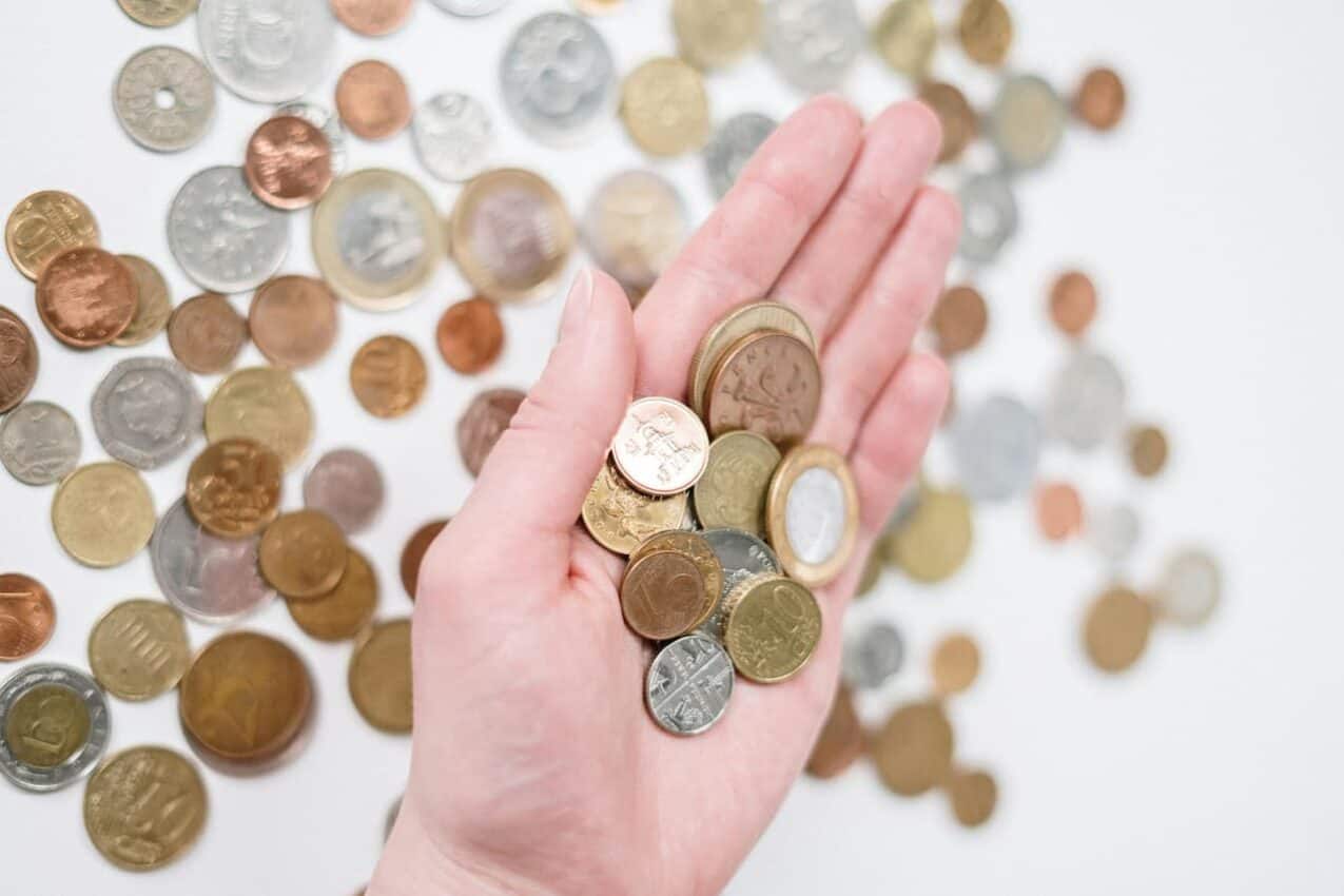 Imagem de uma mão segurando várias moedas