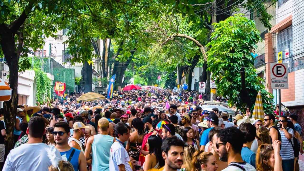 bloco de carnaval de rua em Minas Gerais, espaço com muitas árvores e centenas de pessoas