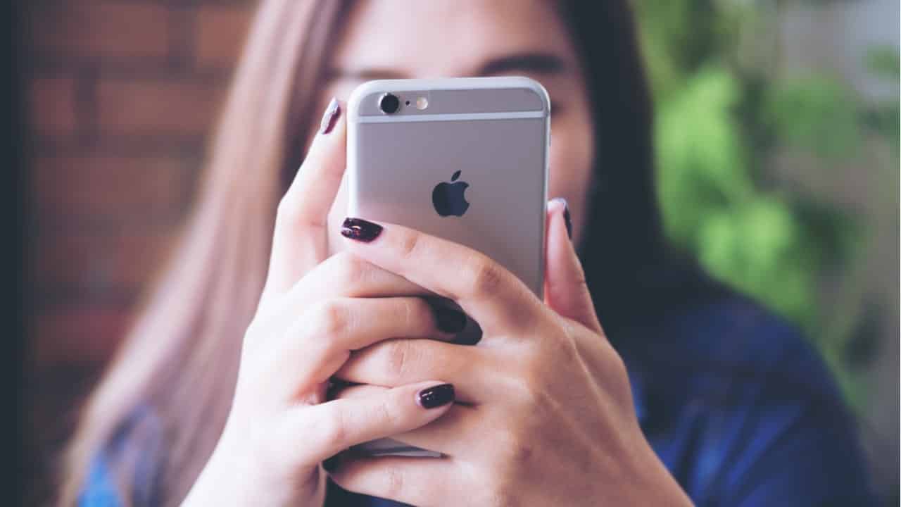 imagem de um iPhone na mão de uma mulher