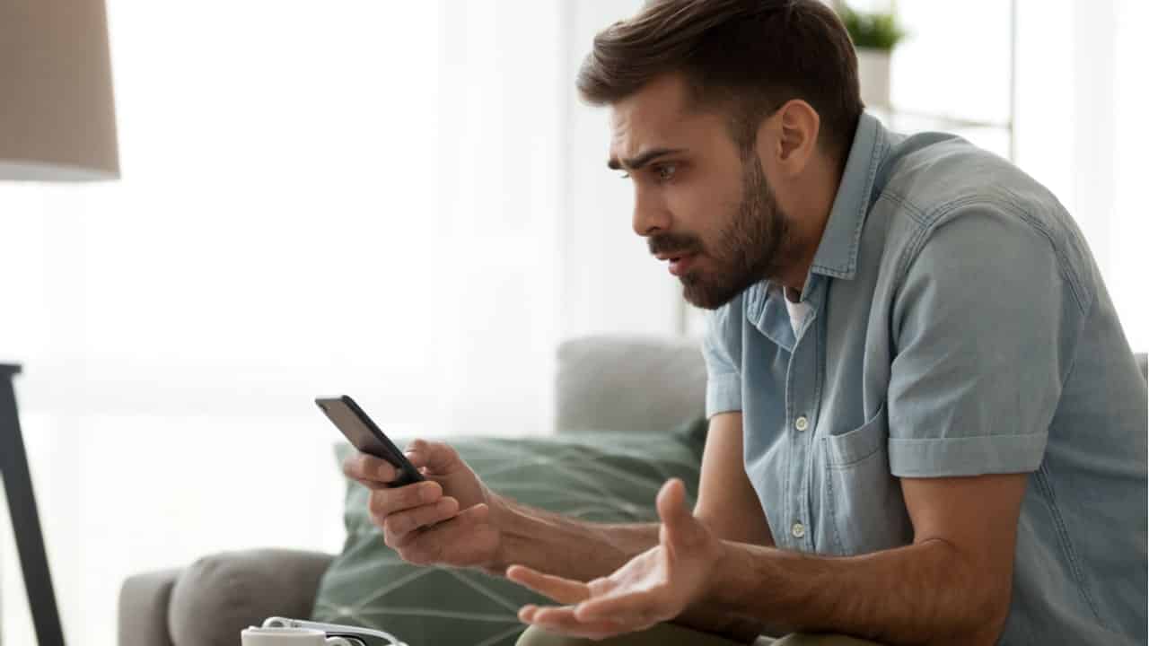 Homem assustado olhando para o celular