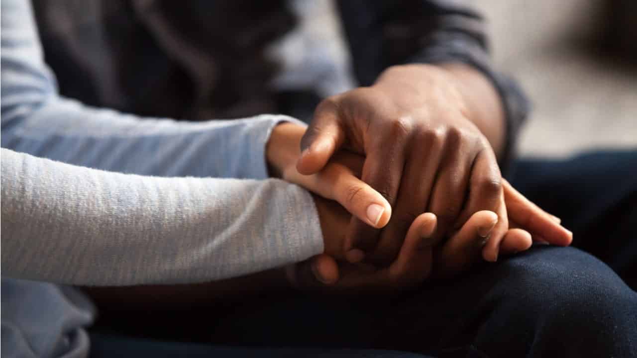 Mãos de um casal se entrelaçando, em alusão ao conceito de união estável.
