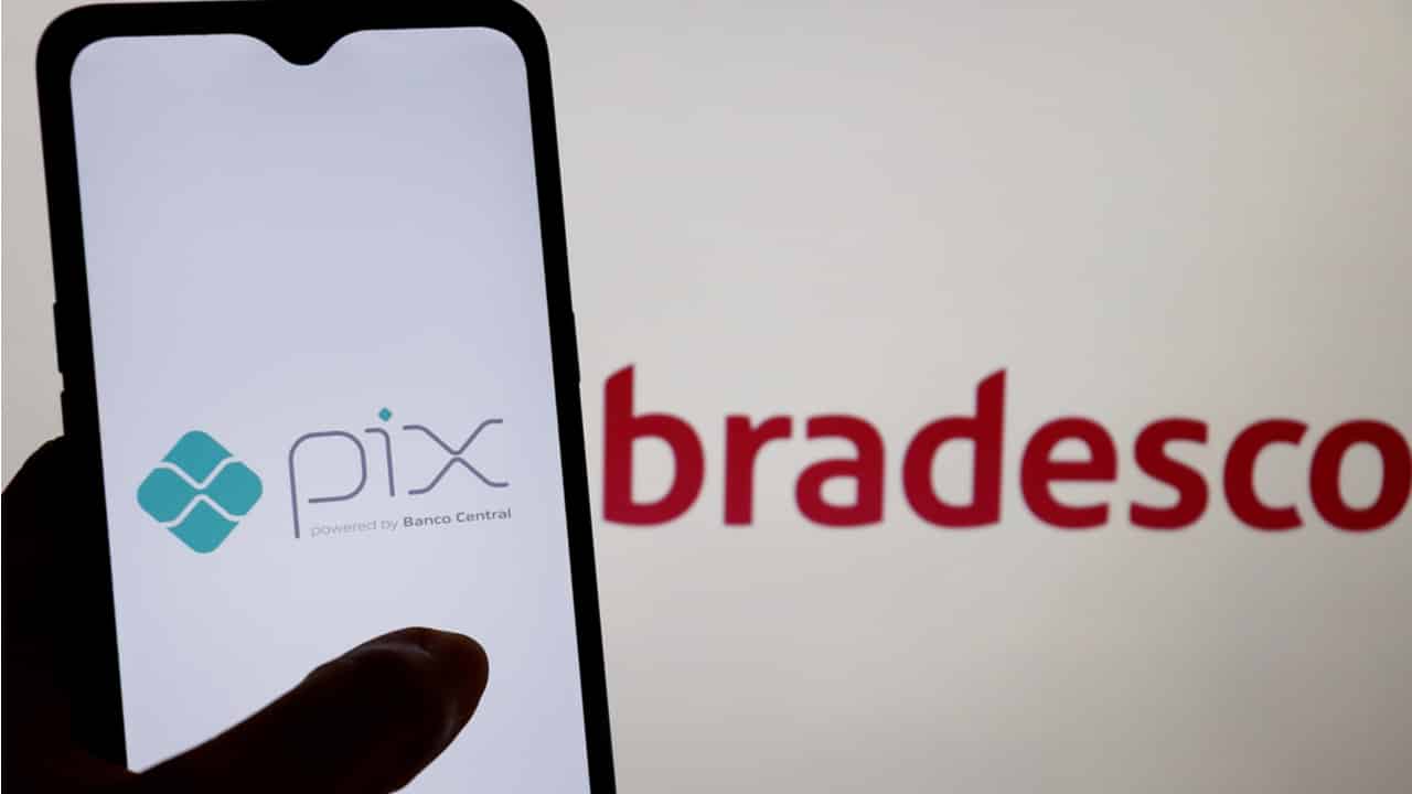 Celular com logo do Pix e banco Bradesco ao fundo
