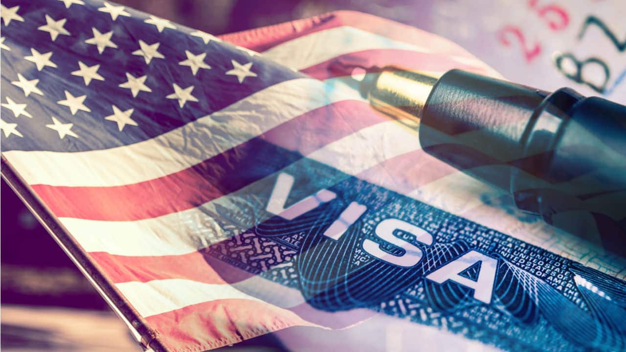 imagem mostrando bandeira dos Estados Unidos, uma caneta e o visto de viagem visto dos EUA