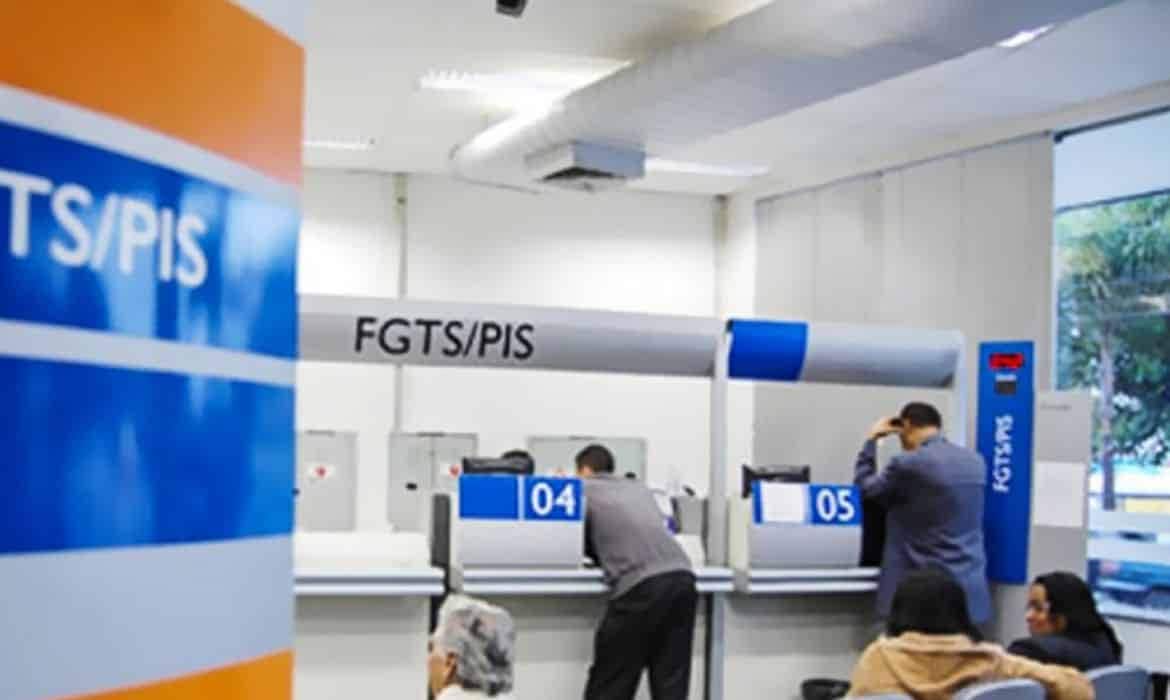 Pessoas sendo atendidas em agência da Caixa, seção FGTS/PIS