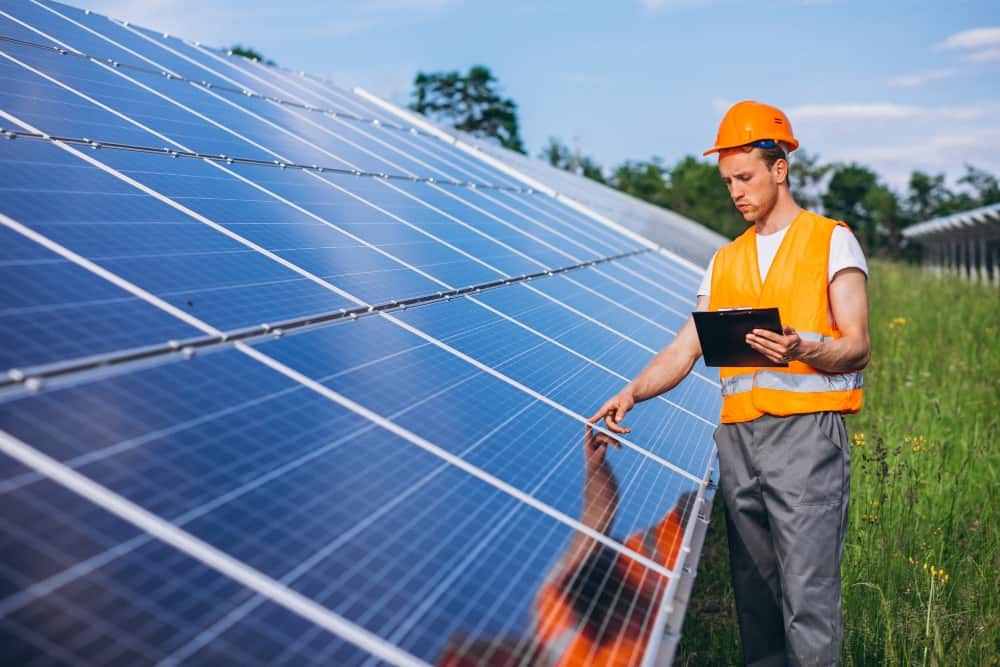 Imagem mostrando painéis solares e um técnico avaliando o equipamento