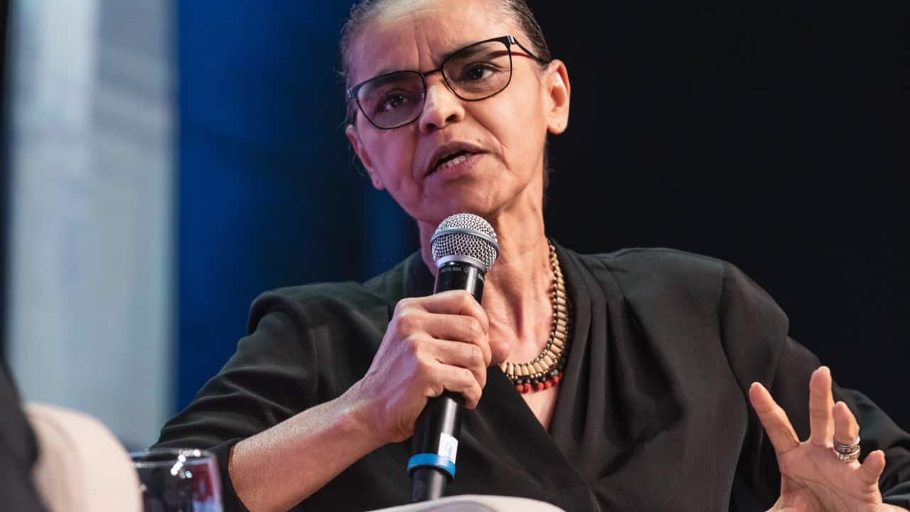 Marina Silva falando enquanto segura um microfone