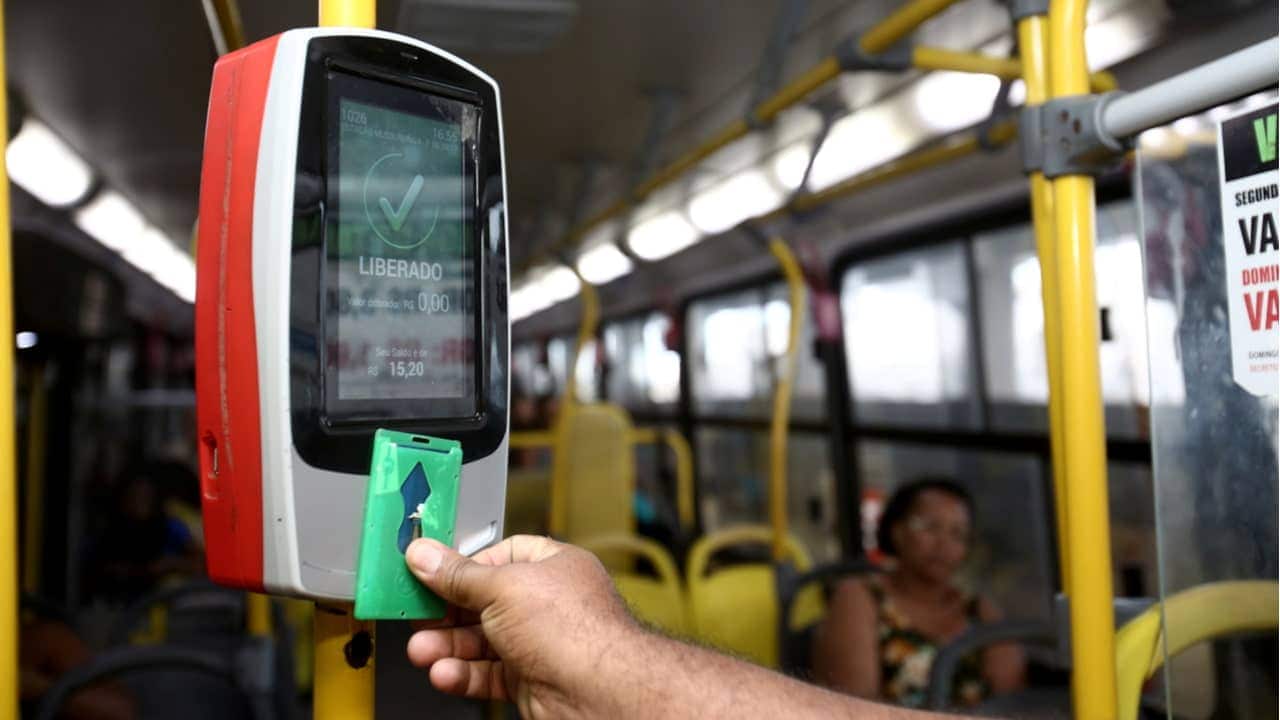 Passageiro usando cartão para liberar passagem na catraca em viagem de ônibus
