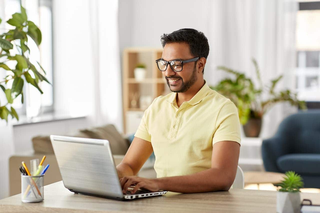 Homem usando um notebook em casa