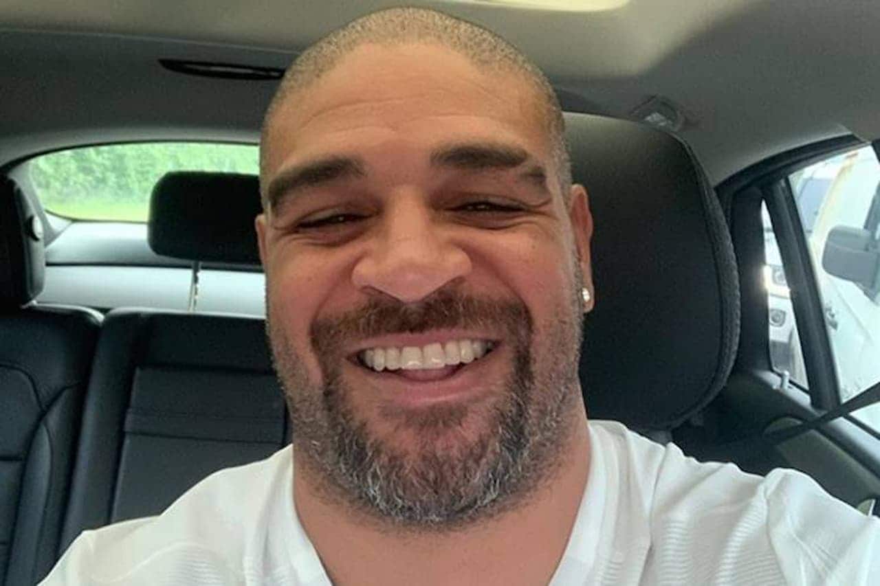Adriano Imperador sorrindo, sentado dentro de um carro