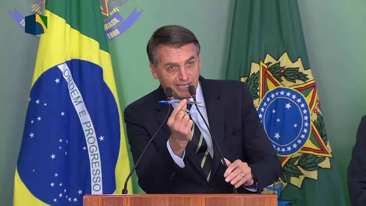 Jair Bolsonaro segurando nas mãos uma caneta Bic