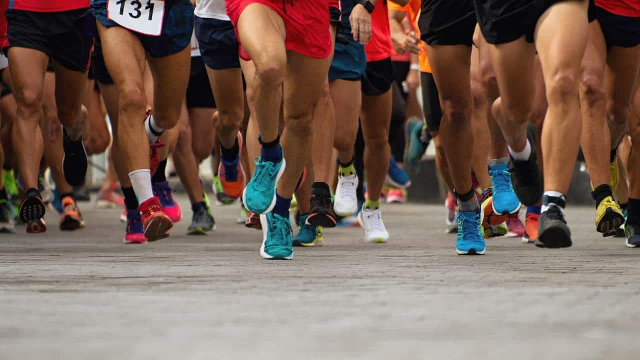 Imagem aproximada nas pernas de vários maratonistas correndo