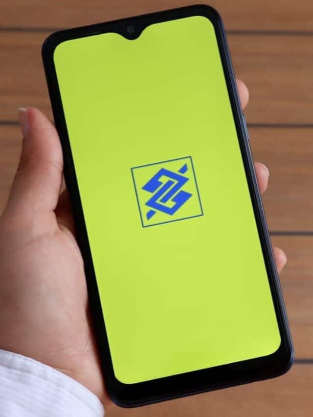 Mão segurando celular que mostra logo do Banco do Brasil