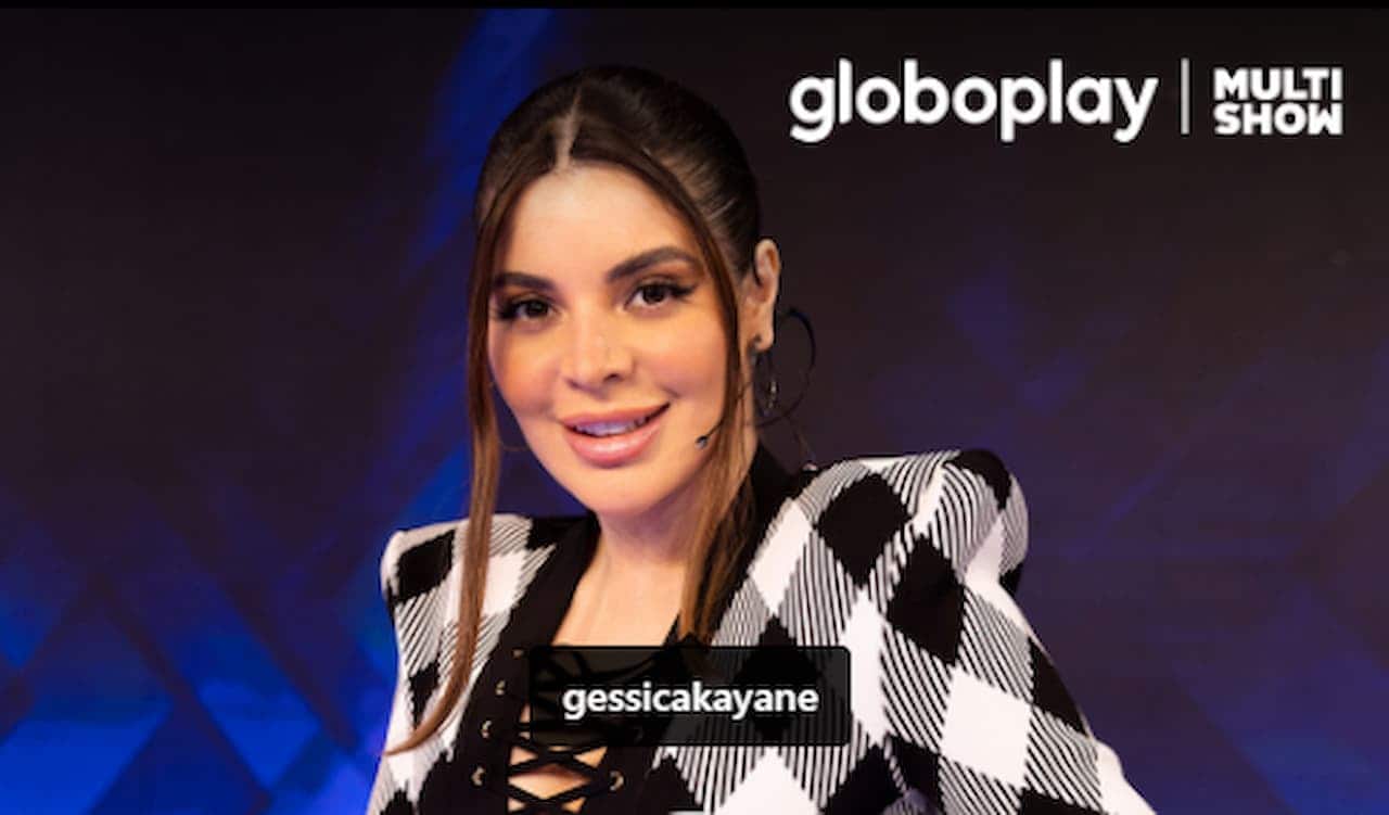 Imagem da influenciadora Gkay sentada em uma poltrona e sorrindo.