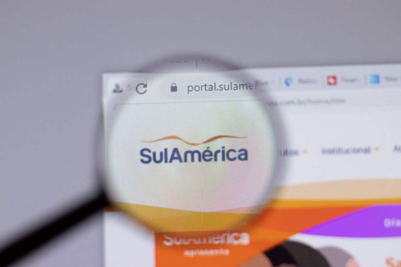 Logo da SulAmérica na tela de um monitor e ampliado por uma lupa