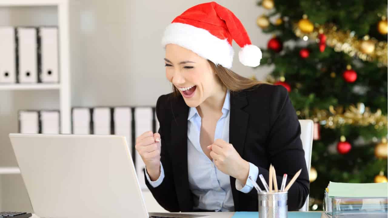 mulher trabalhando no Natal e ano Novo olha para o computador empolgada