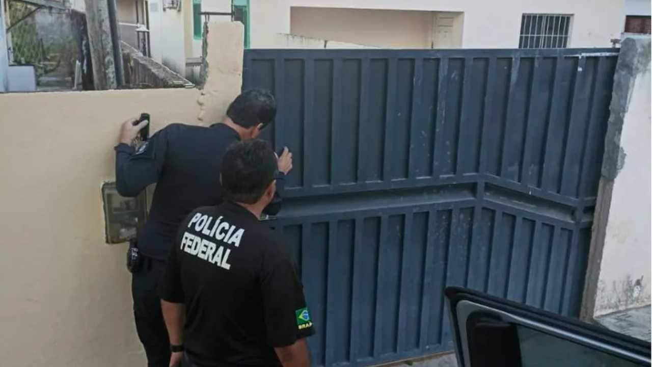 Dois policiais Federais abrindo um portão durante a Operação Subprime