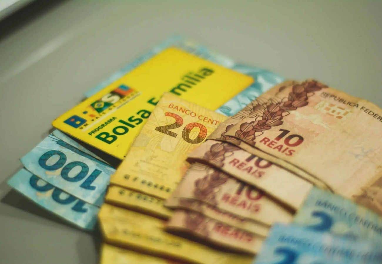 dinheiro e um cartão do bolsa família para representar o benefício social