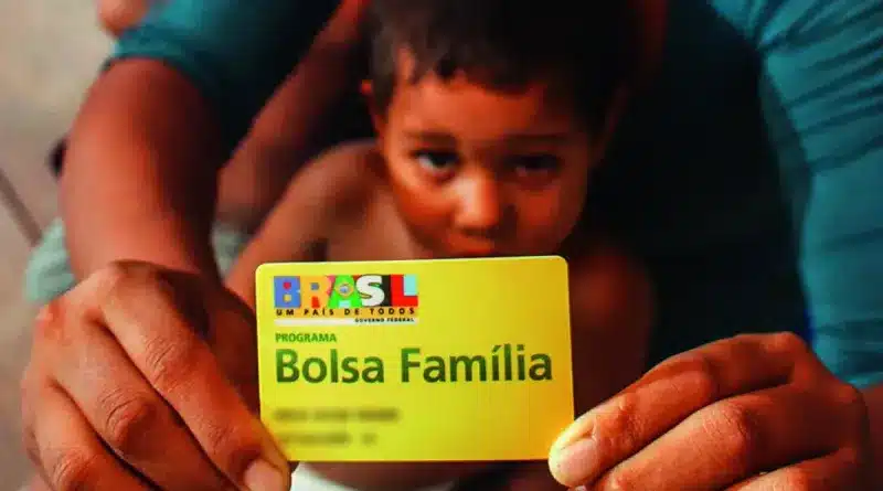 criança segurando cartão do bolsa família que dá direito ao seu pagamento extra