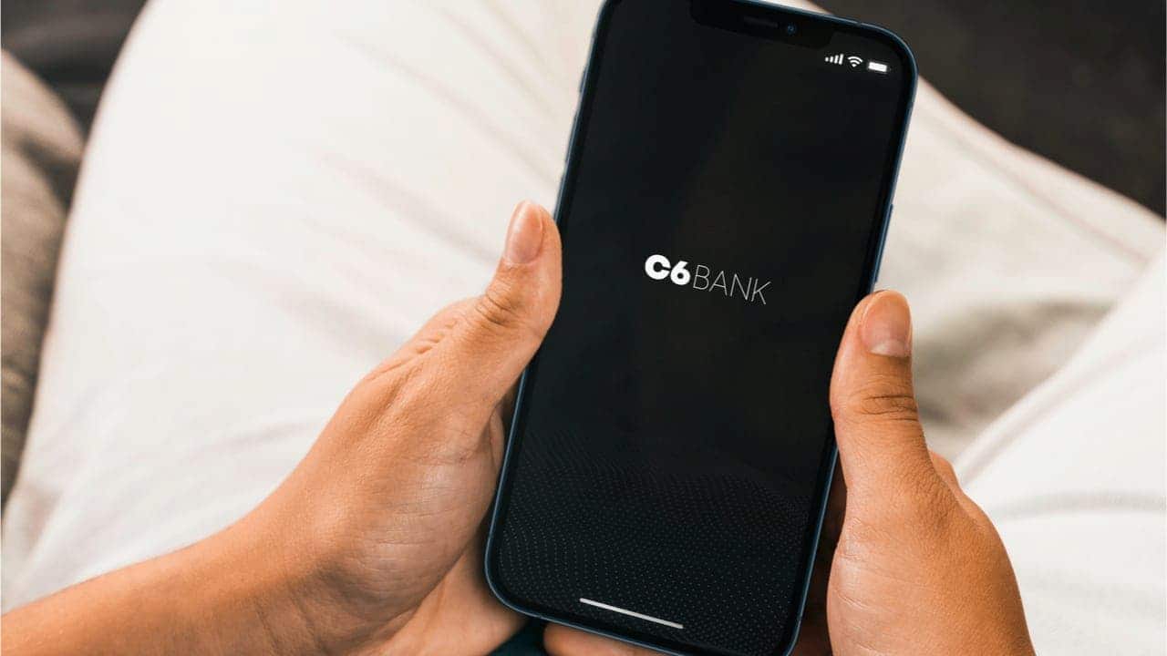 Uma pessoa segurando o celular com o aplicativo do C6 Bank