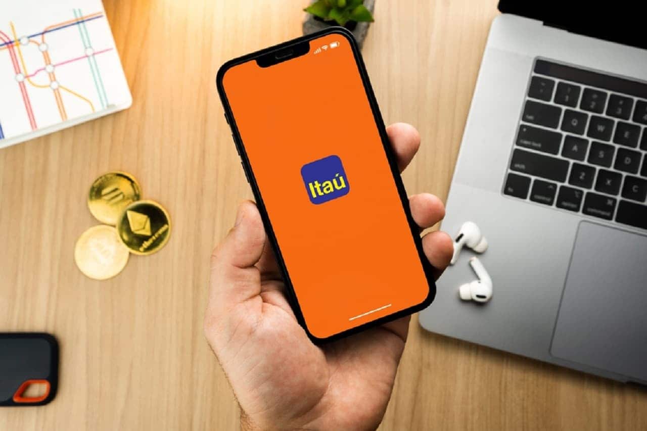 Imagem de uma pessoa segurando o celular com a tela ligada do app do Itaú.