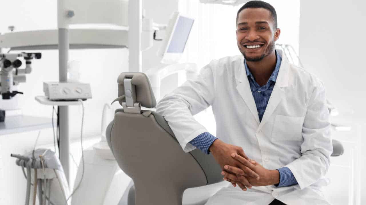 dentista sorrindo em seu consultório