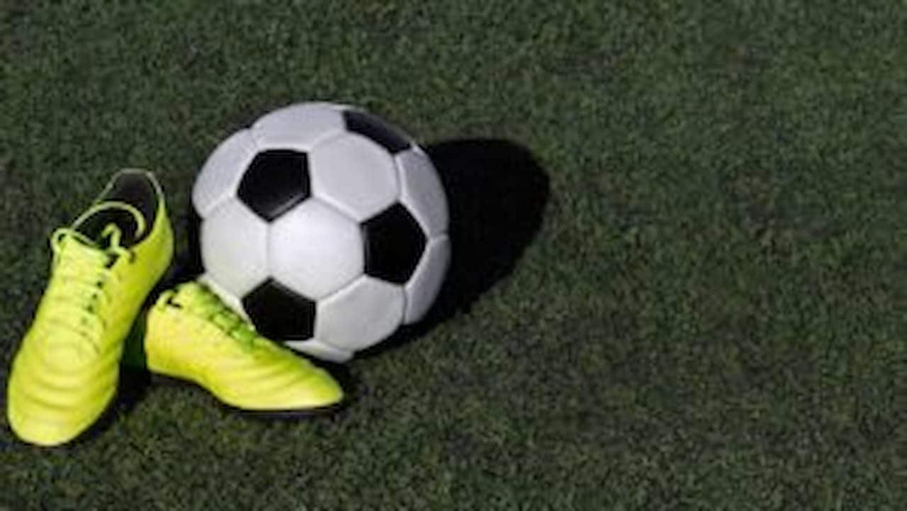 chuteiras e bola de futebol
