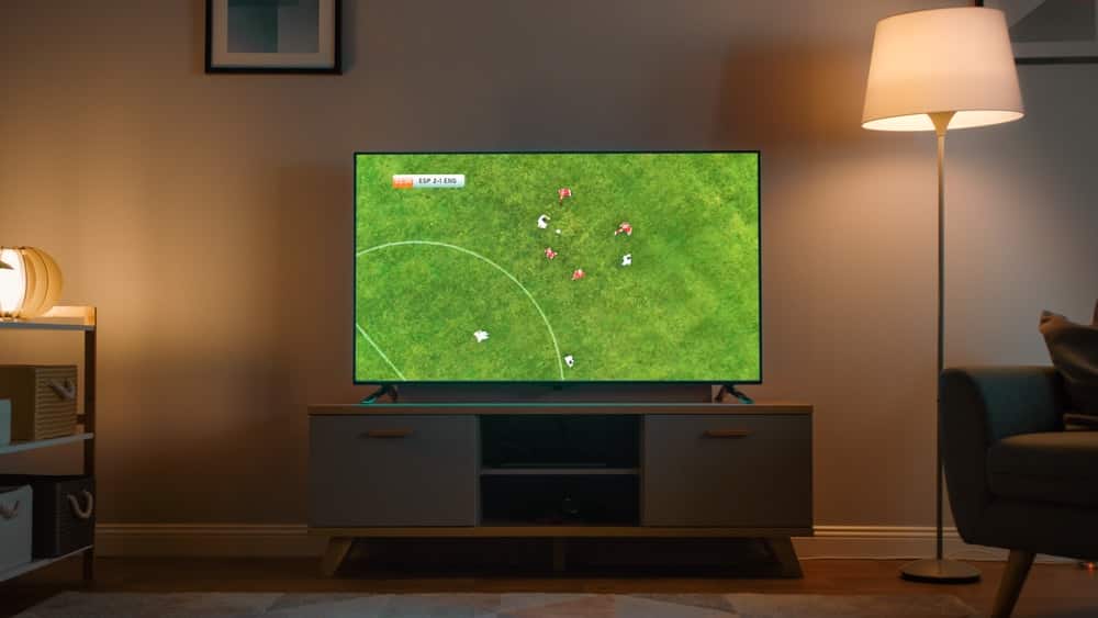 Imagem de uma televisão ligada em um jogo de futebol.