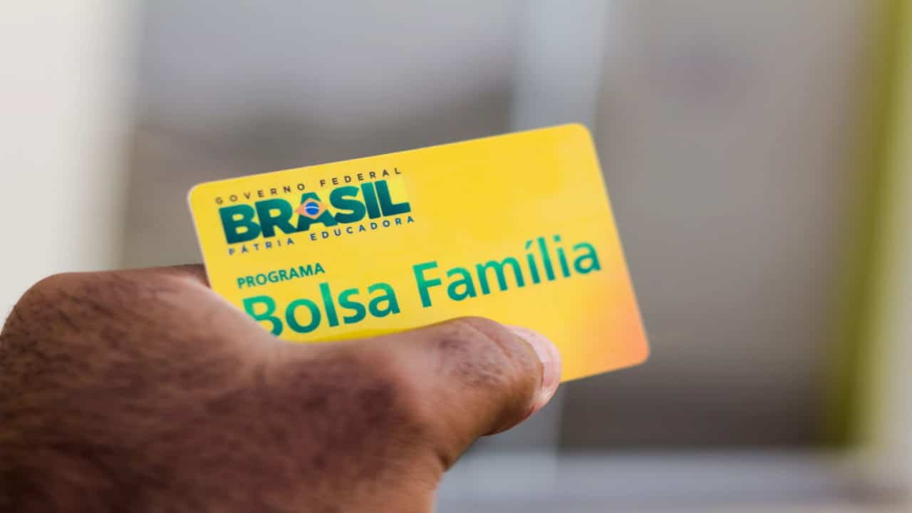 Pessoa segurando um cartão do Bolsa Família