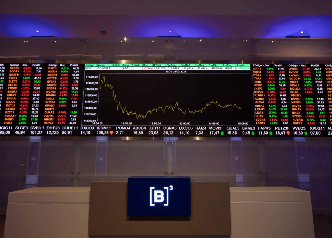 Bolsa de Valores com painel de negociações atrás para investidores.