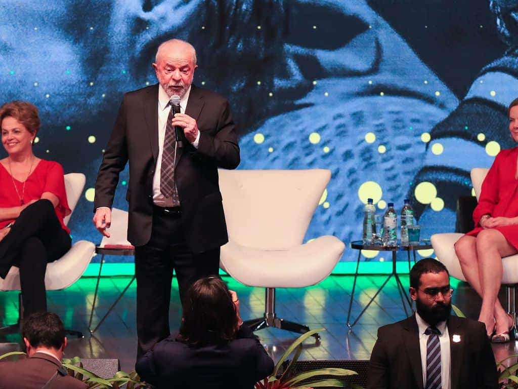 Lula discursando ao lado de Gleisi e Dilma.