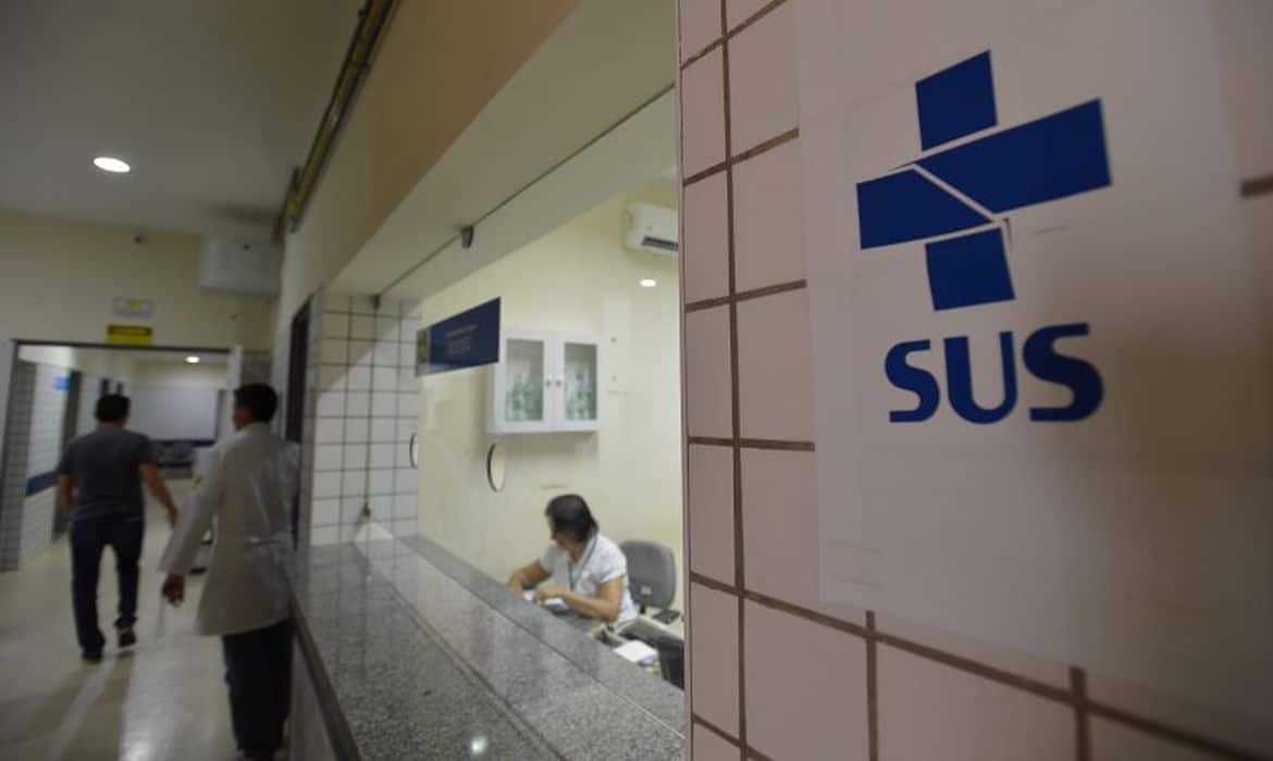 Atendimento de um ambulatório com um adesivo com o logotipo do SUS