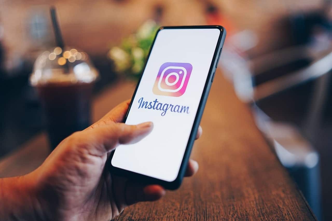 Mão segurando um smartphone com o aplicativo do Instagram na tela