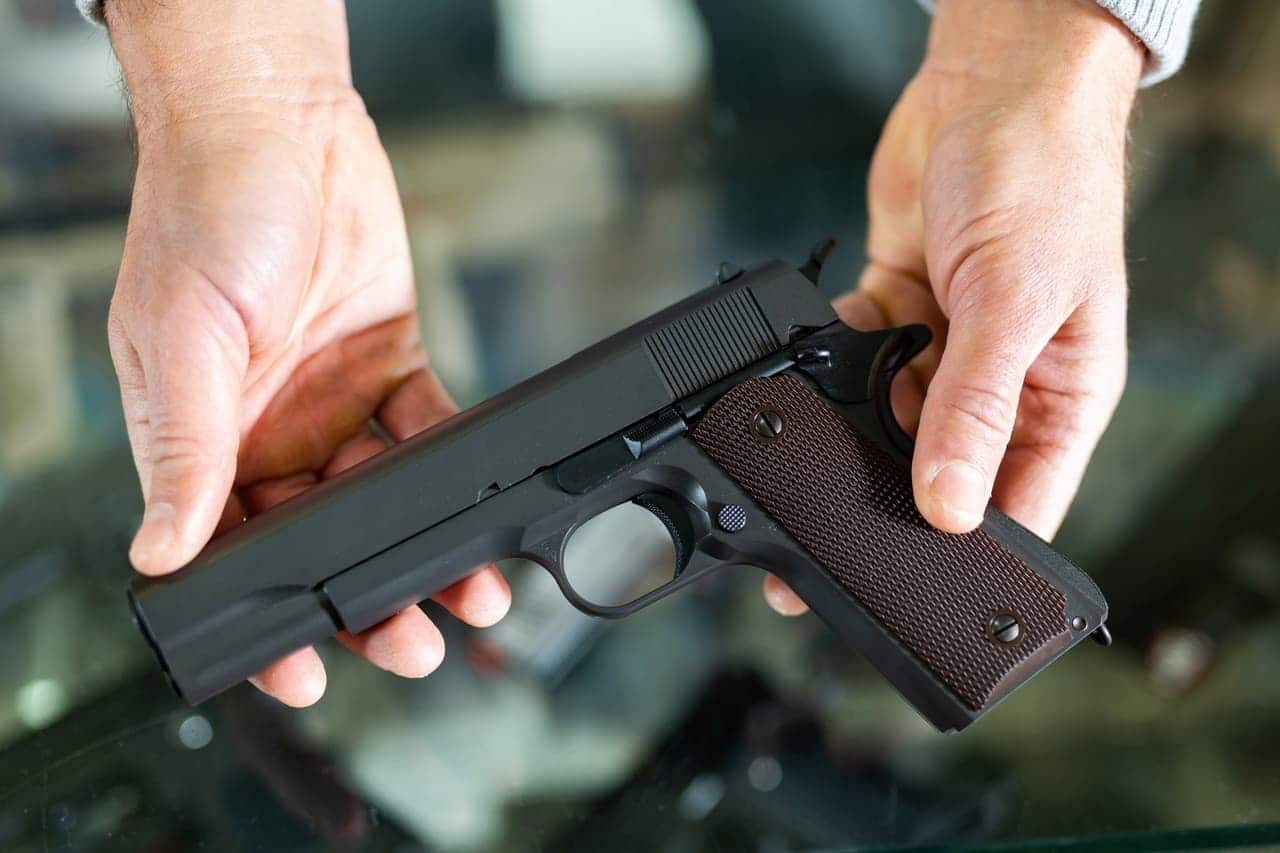 Duas mãos segurando uma arma