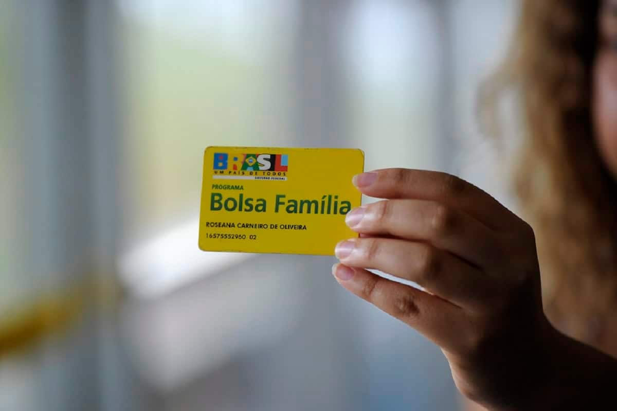 Pessoa segurando um cartão do Bolsa Família