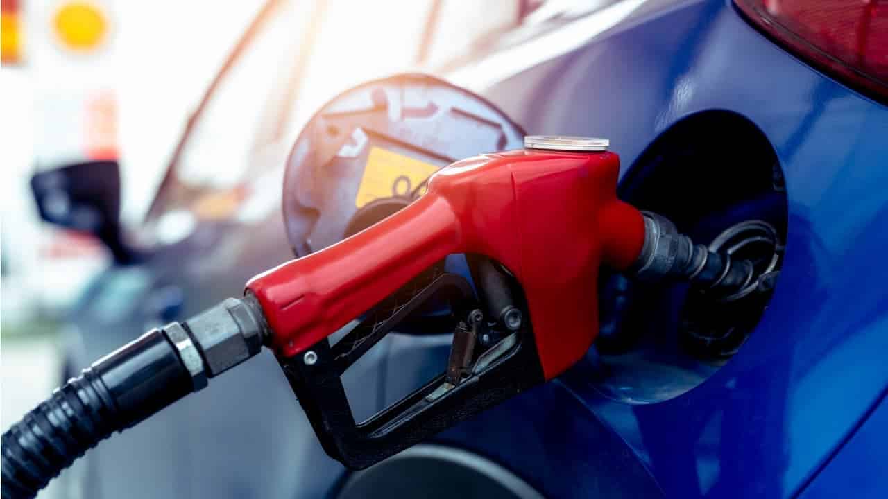 Carro azul recebendo combustível no tanque