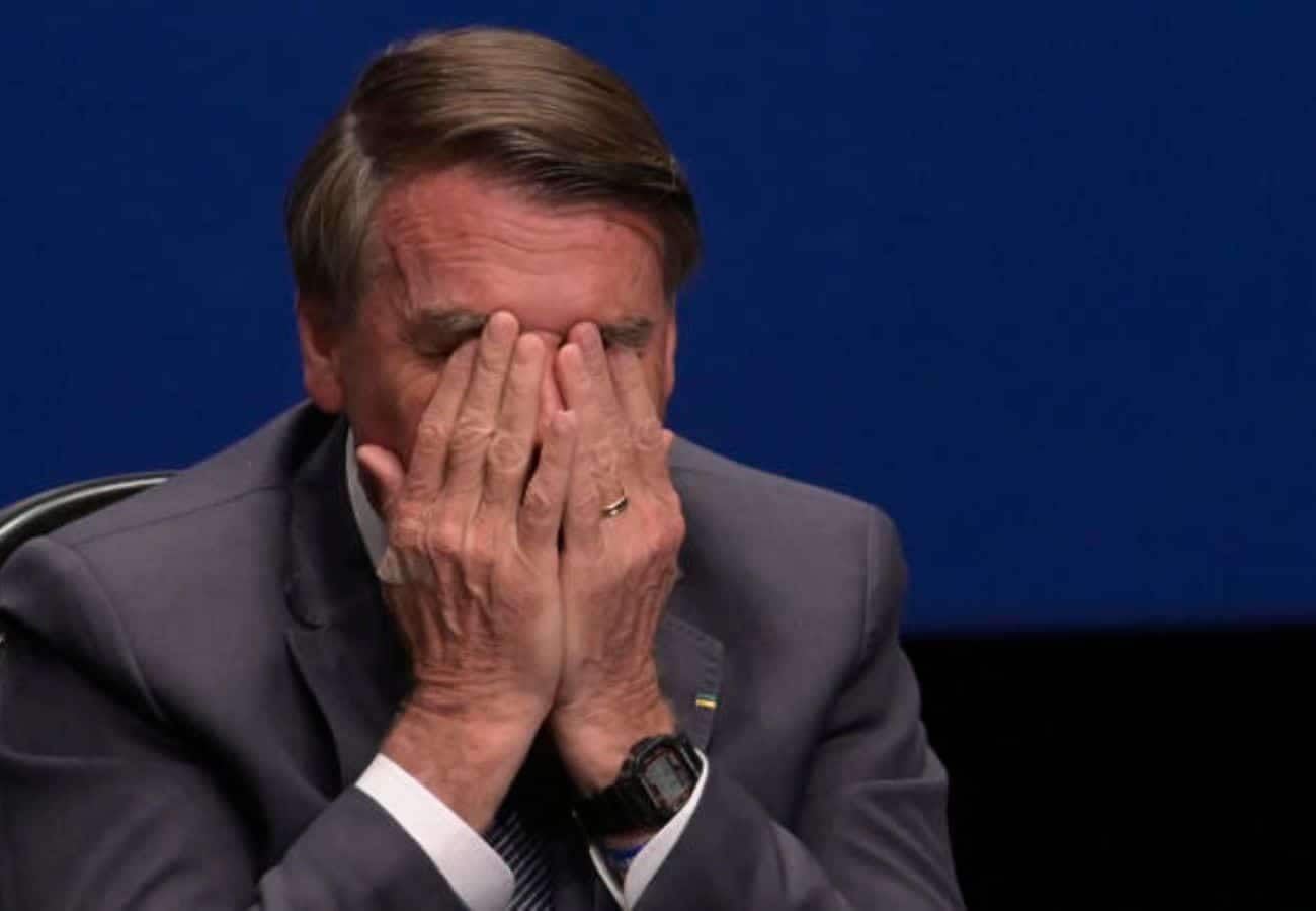 ex-presidente Bolsonaro com as duas mãos no rosto sobre denúncia