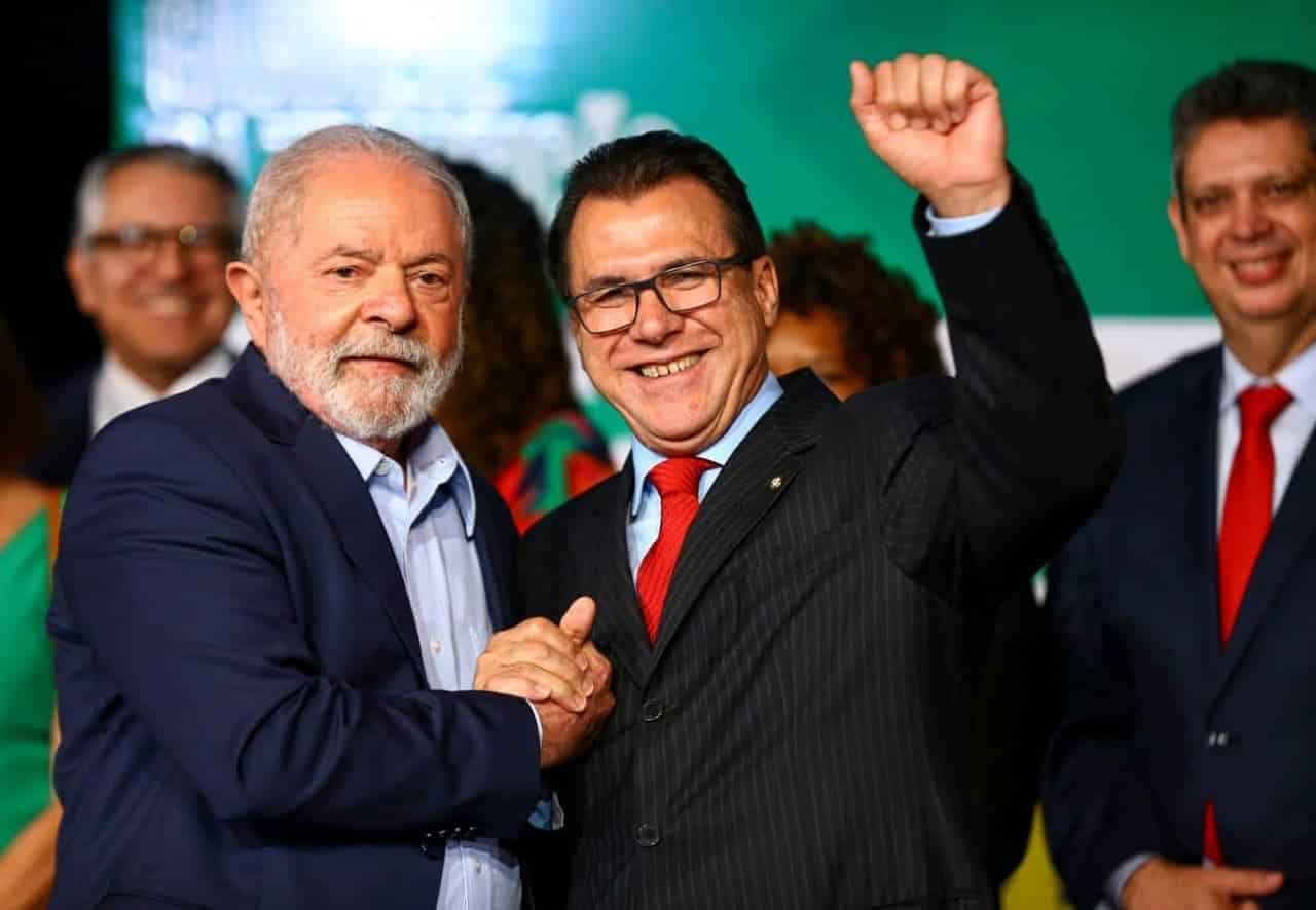 Luiz Marinho, ministro do Trabalho aperta mão do presidente Lula enquanto sorri