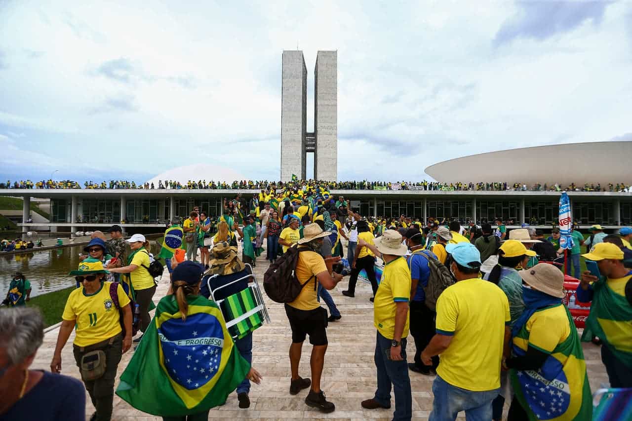 grupo de pessoas, supostamente bolsonaristas, utilizando a camisa da seleção brasileira e bandeiras do país em Brasília , no palácio do planalto