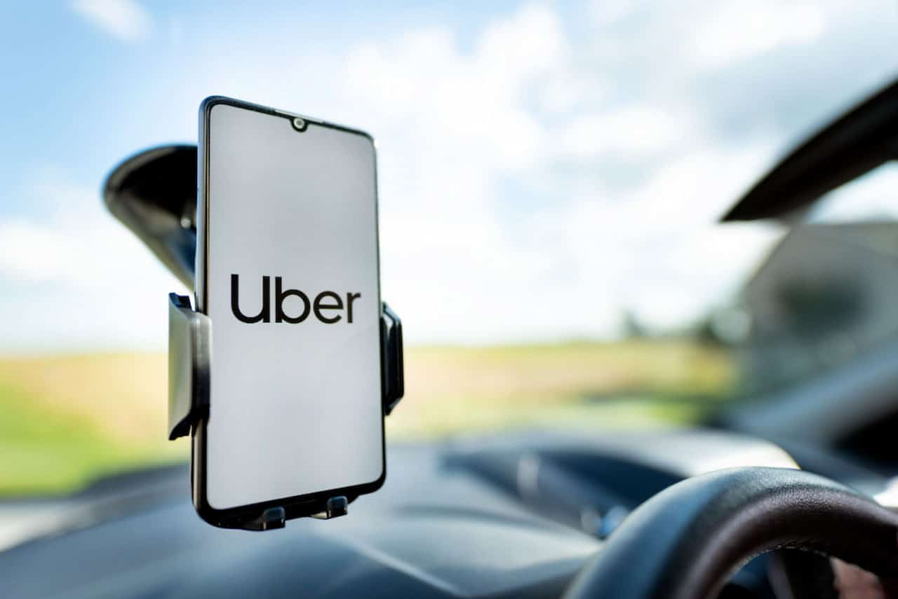 Colocado em um suporte para carro, celular exibe logotipo da Uber