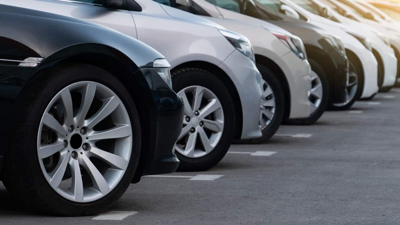 Parte frontal de vários veículos lado a lado em estacionamento