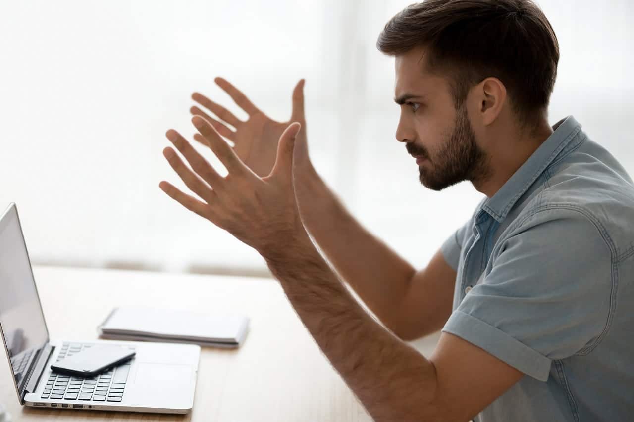 Imagem mostra um rapaz olhando indignado para a tela do computador.