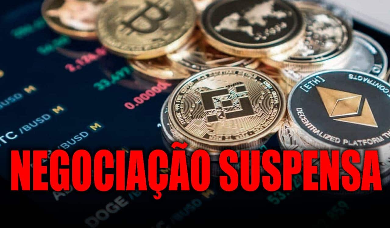 Vários tipos de criptomoedas sobre um painel de trades com o texto "Negociação Suspensa" na parte de baixo